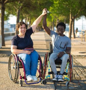Couple in wheelchairs holding hands