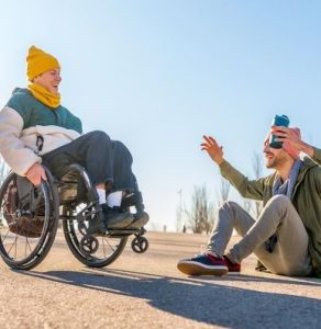 Young disabled woman enjoying a sunny park day, playing joyfully with her friend, sharing laughter and creating lasting memories together